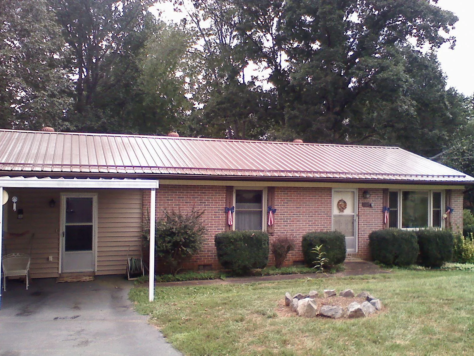 Bronze metal roof and carport on a brick ranch home — Roof Repair work by our crew in Dumfries